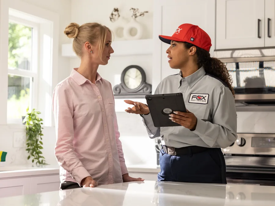 Fox Pest Control technician talking to female customer